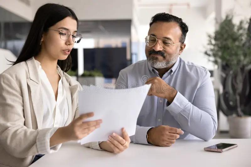 serious asian female tax advisor glasses giving financial consultation young legal expert advice to senior indian businessman 417790761